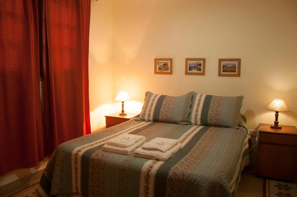een slaapkamer met een bed met twee handdoeken erop bij Hostería La Pergola in Villa Serranita