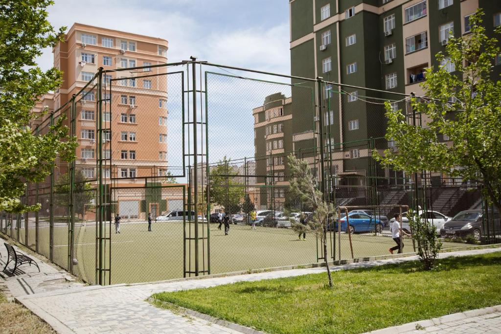 a tennis court in a city with buildings at SelfHouse in Masazır