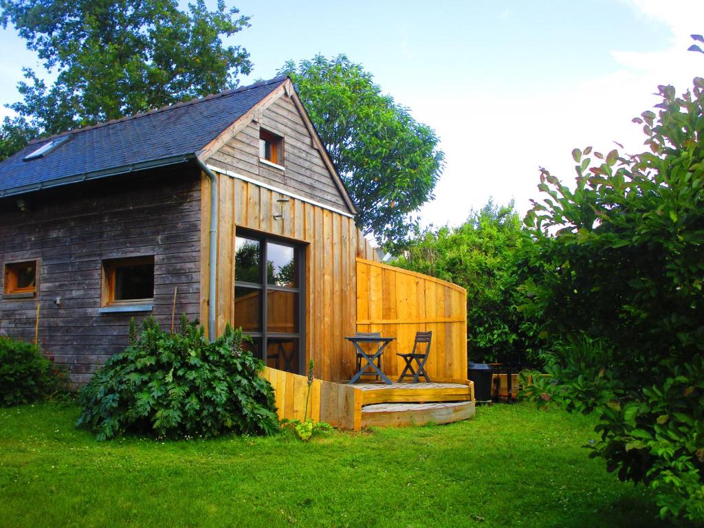 une petite maison en bois avec une table dans une cour dans l'établissement Eco maisonnette, à Sulniac