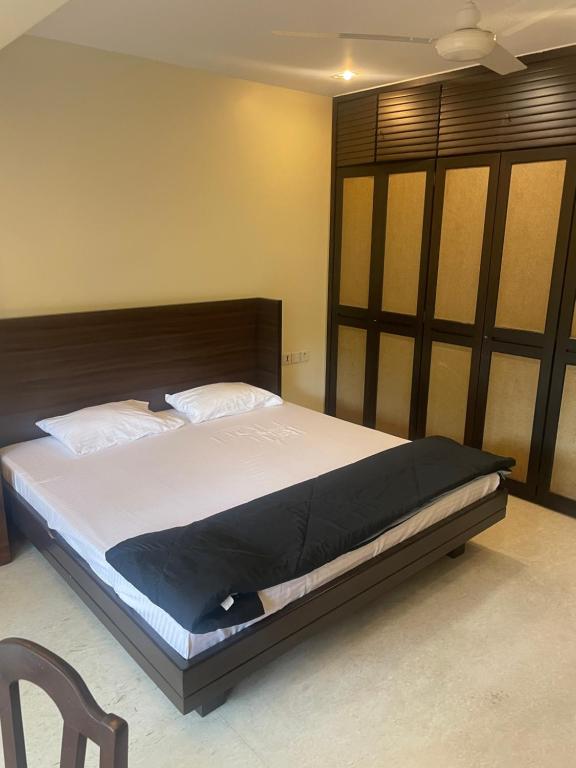 een slaapkamer met een groot bed met een houten hoofdeinde bij Penthouse retreat by speed homes in Calcutta
