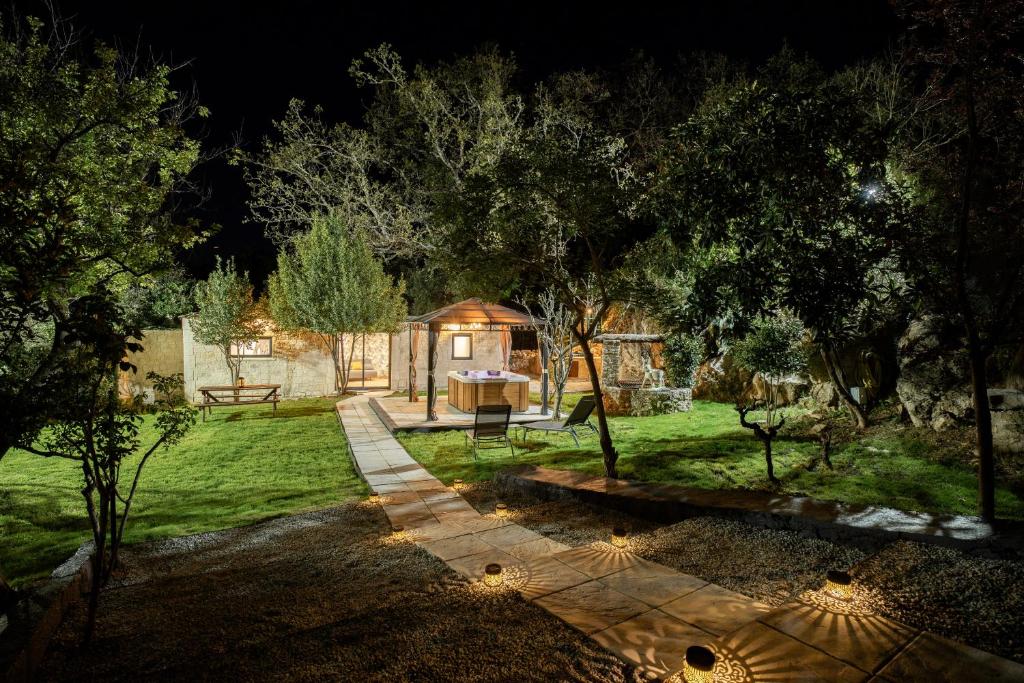 a garden at night with a house in the background at Ô Jacuzzi du Mazet in Murles