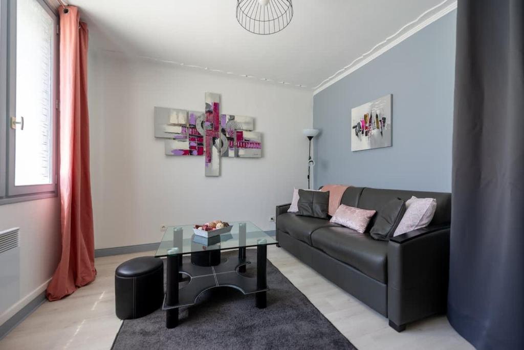 un salon avec un canapé et une table en verre dans l'établissement Logement Vacances La Rochelle, à Aytré