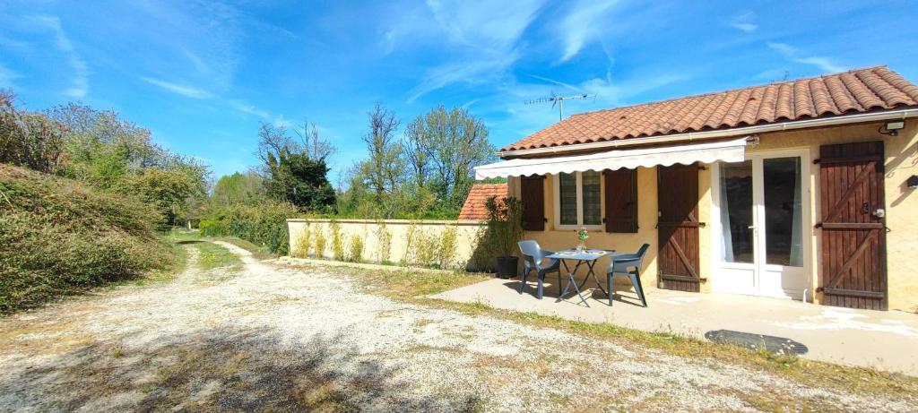 une petite maison avec une table et des chaises à l'extérieur dans l'établissement Gite d en Haut, à Sarlat-la-Canéda