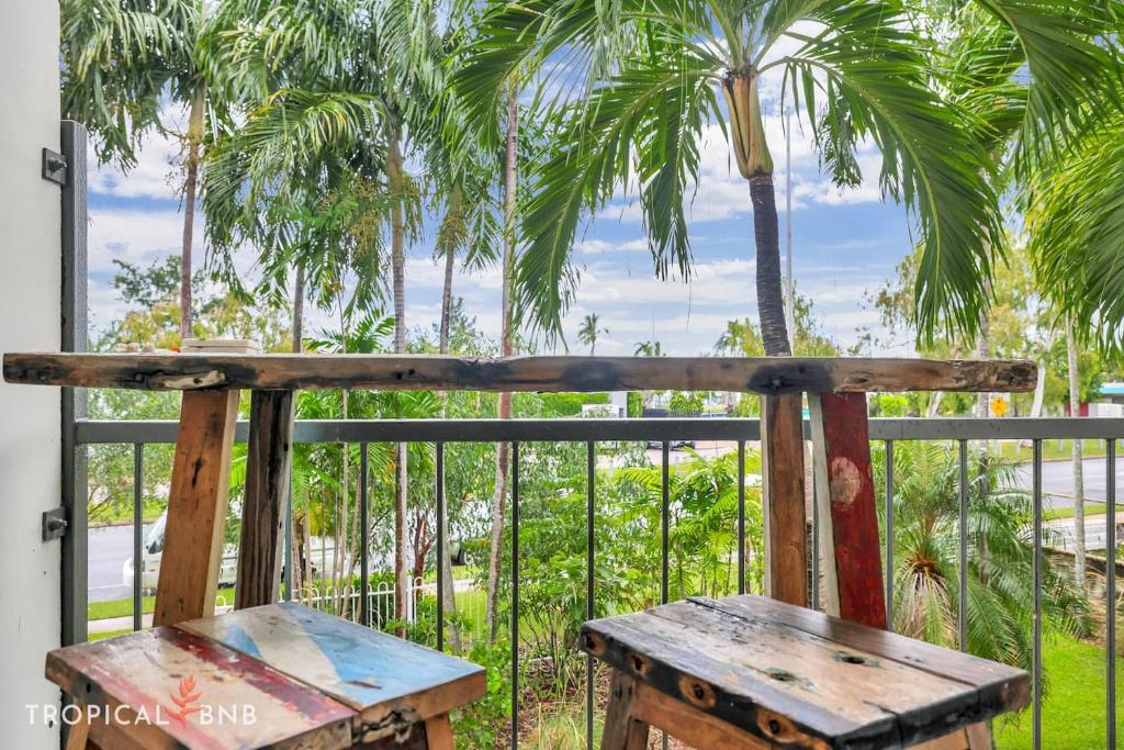 NightcliffBeachfront Bliss Studio Apt On The Foreshore的棕榈树阳台的木凳