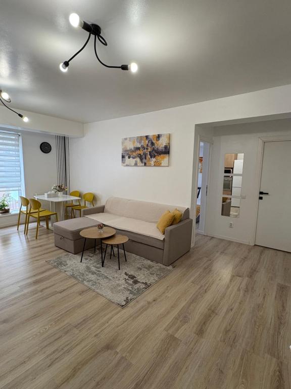 a living room with a couch and a table at Yellow Apartment in Floreşti