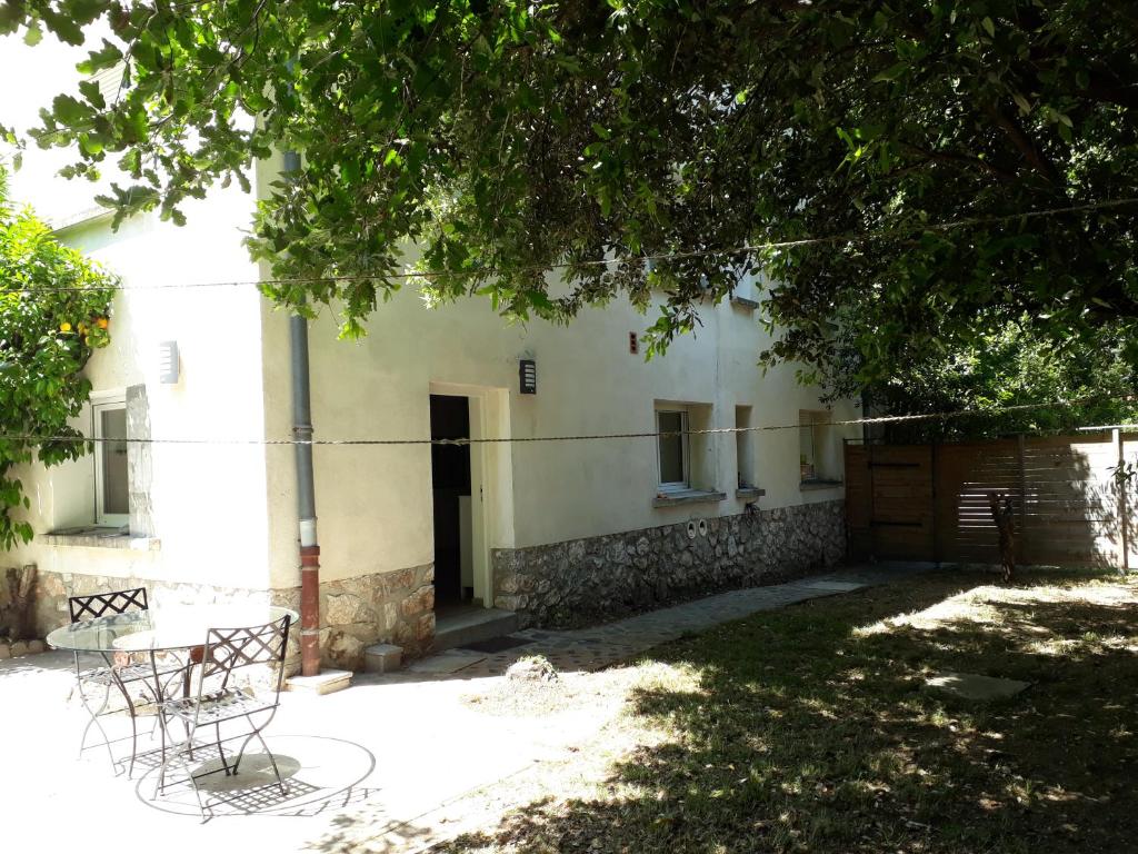 un bâtiment avec une table et des chaises sous un arbre dans l'établissement Villa Pillapi, à Céret