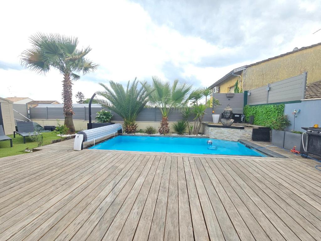 une cour arrière avec une piscine et une terrasse en bois dans l'établissement La villa DOLCE, à Le Bouscat