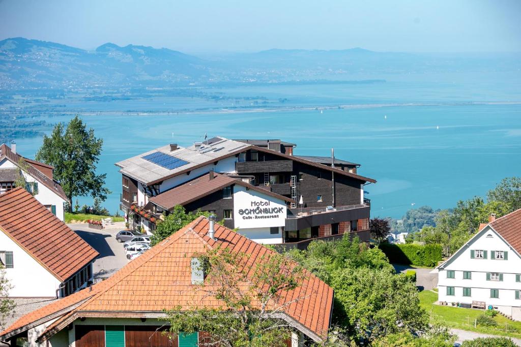 a view of a town with houses and the water at Hotel Schönblick in Lochau