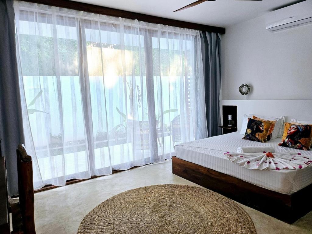 TongoniShungi Villa Zanzibar Trips Included from 3 nights的一间卧室，里面有一张床和一扇大窗户。