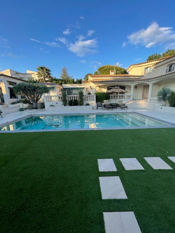 une grande maison avec une piscine et de l'herbe verte dans l'établissement Magnifique suite dans villa de luxe, à La Colle-sur-Loup