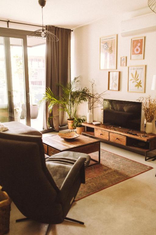 a living room with a chair and a television at Apartament Warmiński Port 50m od jeziora in Olsztyn