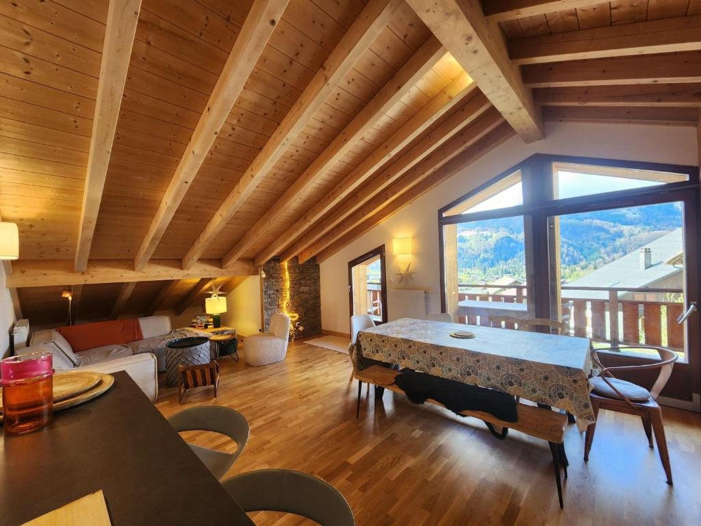 salon ze stołem i dużym oknem w obiekcie Superbe T4 mansardé - 3 chambres - Vue panoramique - Parking privé - FR-1-629-112 w mieście Samoëns