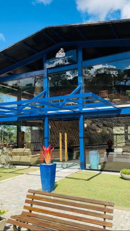 a blue building with a bench in front of it at Hotel Estação Chico in Garanhuns