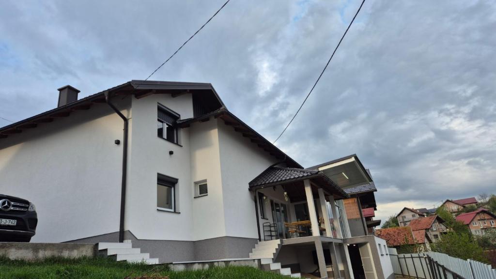 a white house with a black roof at Azur Perla in Sarajevo