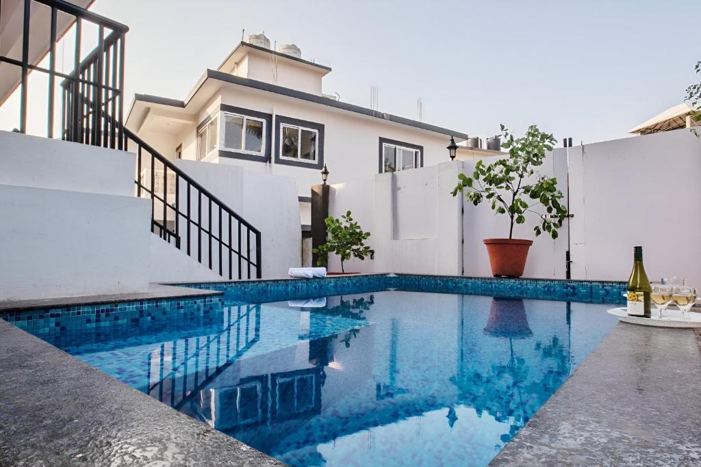 a swimming pool in front of a house at Thor Villa, 5BHK-Private Pool-Cook-Caretaker in Assagao