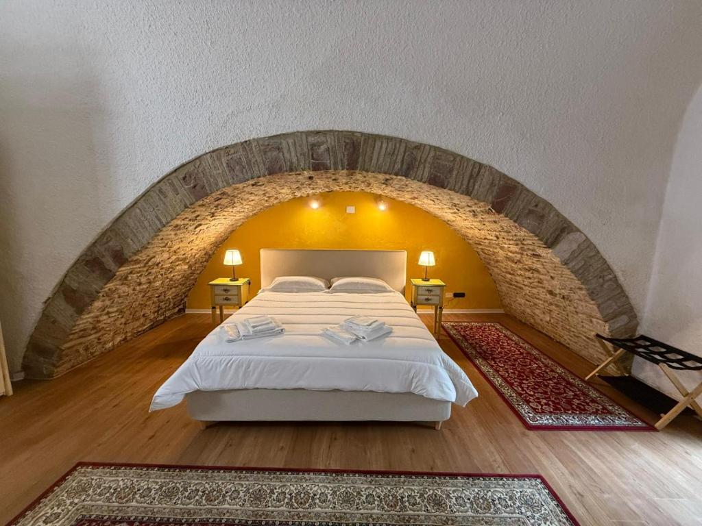 a bedroom with a large bed in a brick wall at Hotel Lieto Soggiorno in Assisi