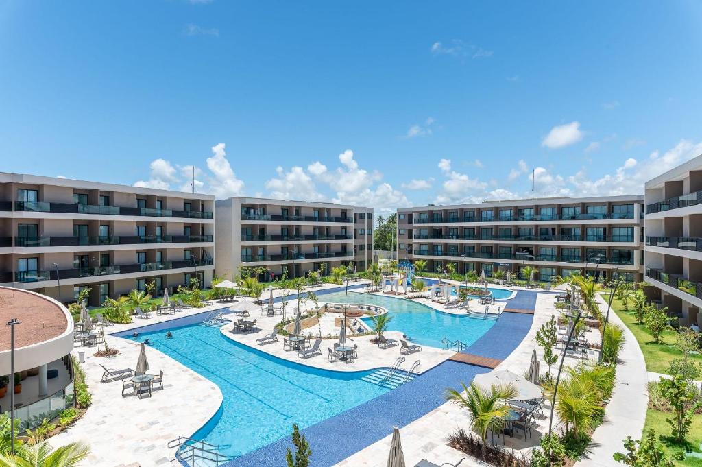 eine Luftansicht eines Apartmentkomplexes mit einem Pool in der Unterkunft Malia Beach Experience Muro Alto Porto de Galinhas por Brevelar in Ipojuca