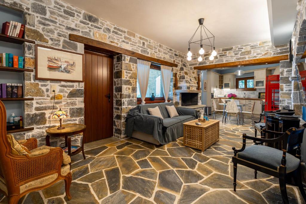 a living room with a stone wall at BARBARELLA Luxury Resort in Agios Ioannis Pelio