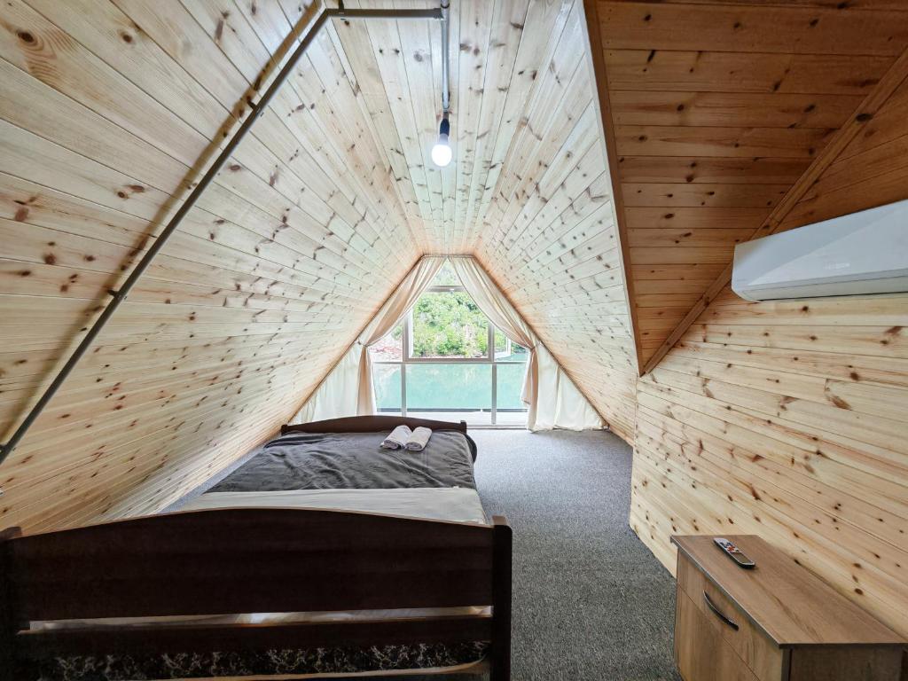 a bedroom in a tree house with a large window at Riverside Komani Lake in Koman