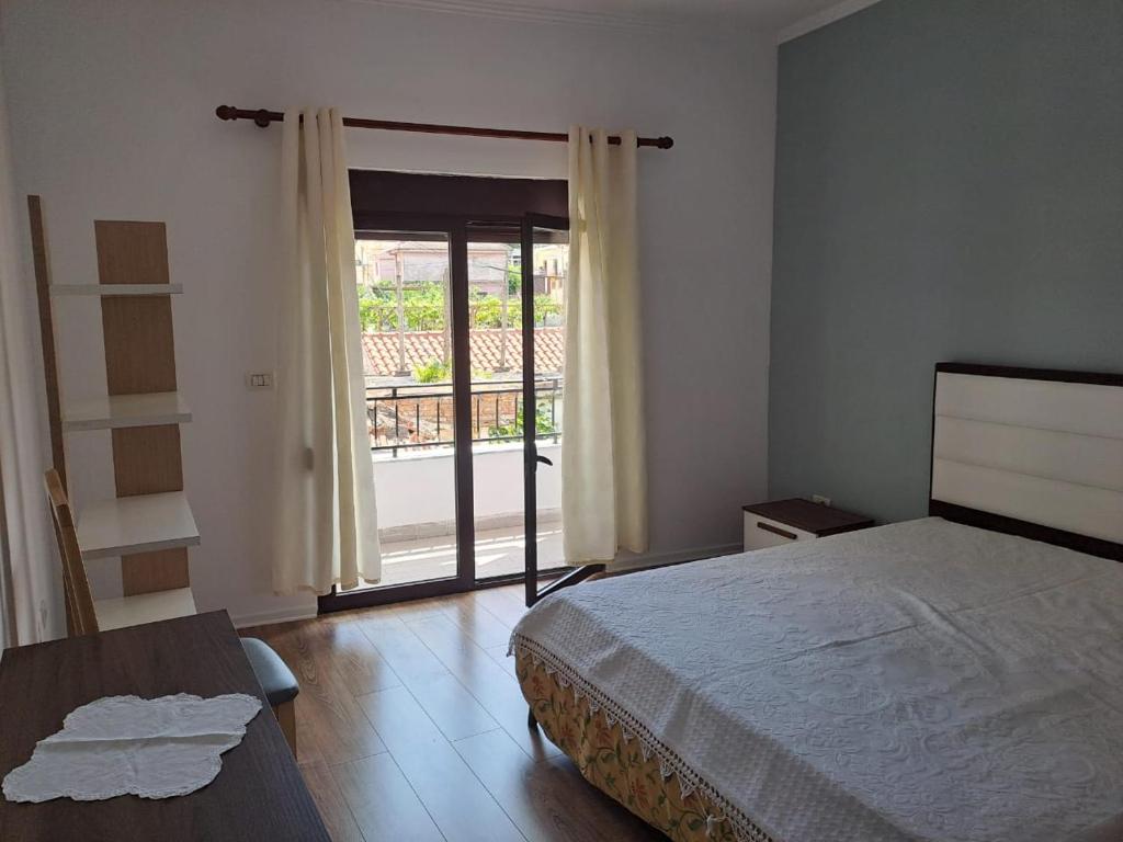 Un dormitorio con una cama y una puerta corrediza de vidrio. en Vila Konti 42, en Durrës
