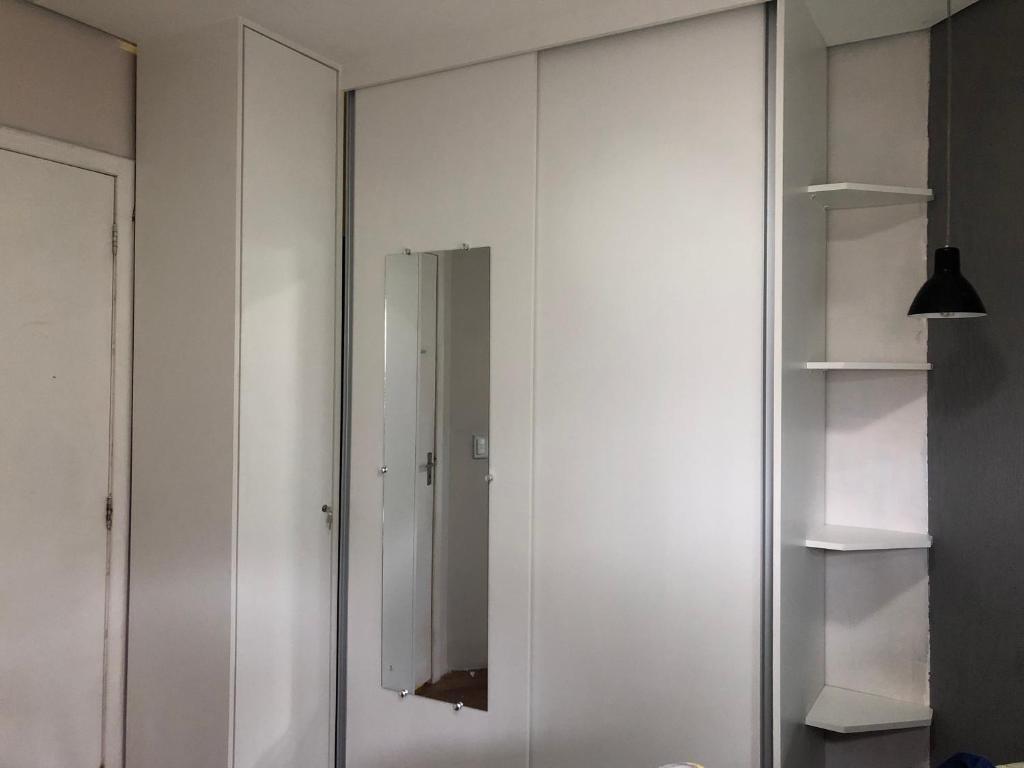 a large white closet with a mirror in a room at São Francisco Apartment in Taboão da Serra