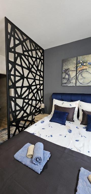 a bedroom with a large bed with towels on it at Apartmani blue i green in Bugojno