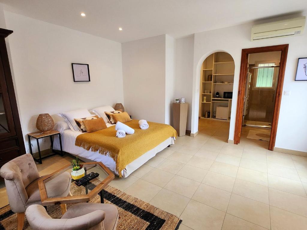 a bedroom with a bed and a living room at Charmant 40 m proche Centre in LʼÎle-Rousse
