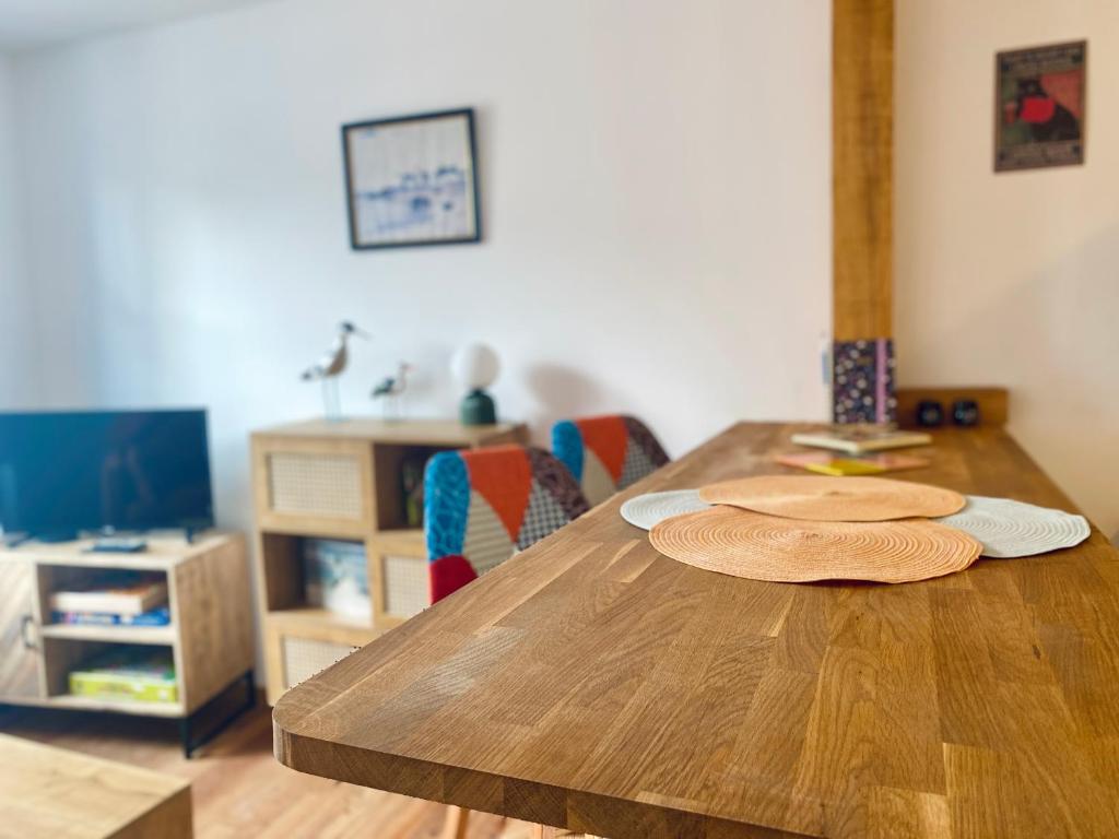 une table en bois avec deux chapeaux en haut dans l'établissement Mignon et cosy à côté de la mer, à Mers-les-Bains