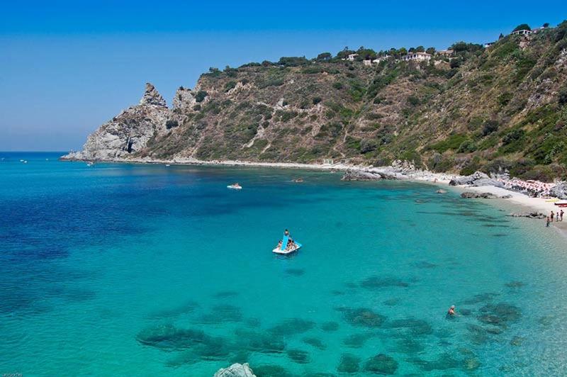 a person in a boat in the water on a beach at Tropea CAPO VATICANO villa - Amphitrite in Capo Vaticano