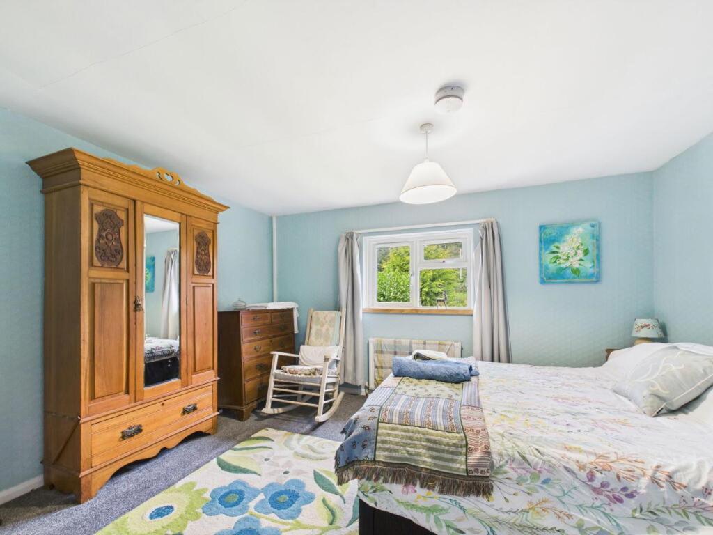 a bedroom with a bed and a dresser and a window at The Hazels in Staunton