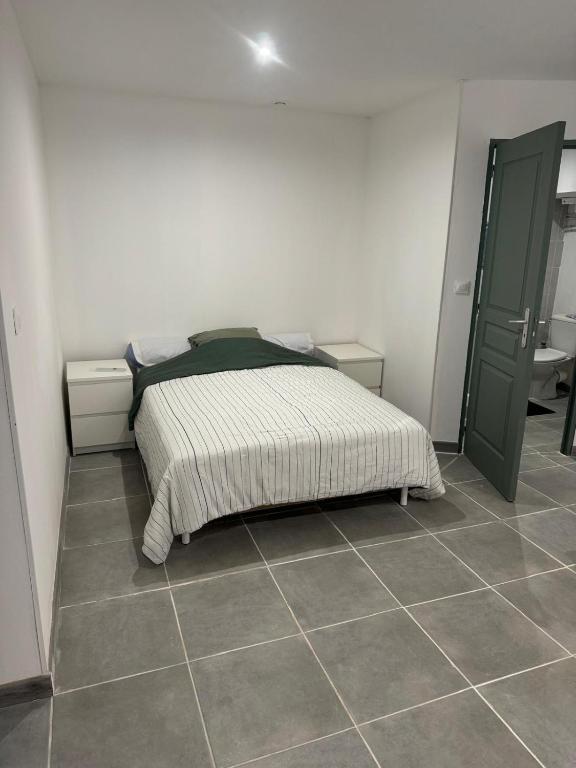une chambre avec un lit et un sol carrelé dans l'établissement Appartement centre ville Béziers, à Béziers