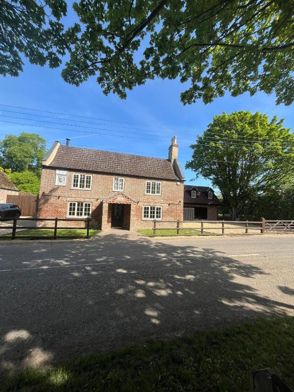an old brick building with a driveway in front of it at Woodpecker Lodge in Frampton