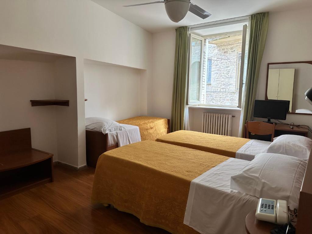 Postel nebo postele na pokoji v ubytování Hotel Roma Assisi