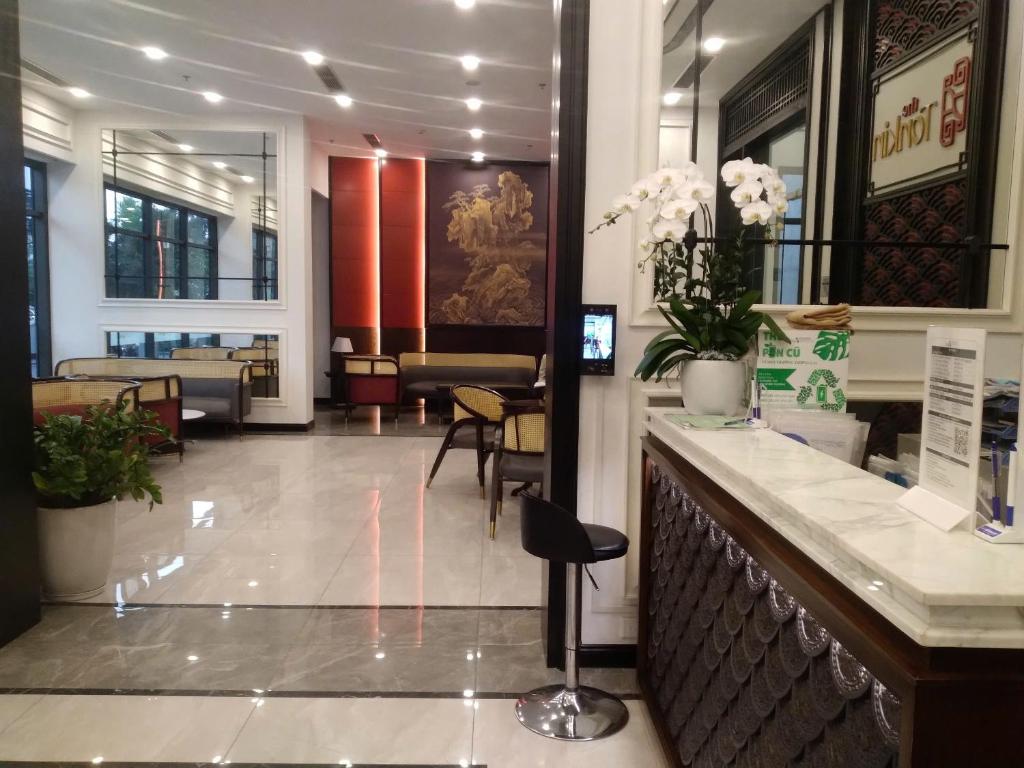 a lobby with a waiting room with a counter and chairs at Tonkin2 Luxhomes Smart City in Phú Thú