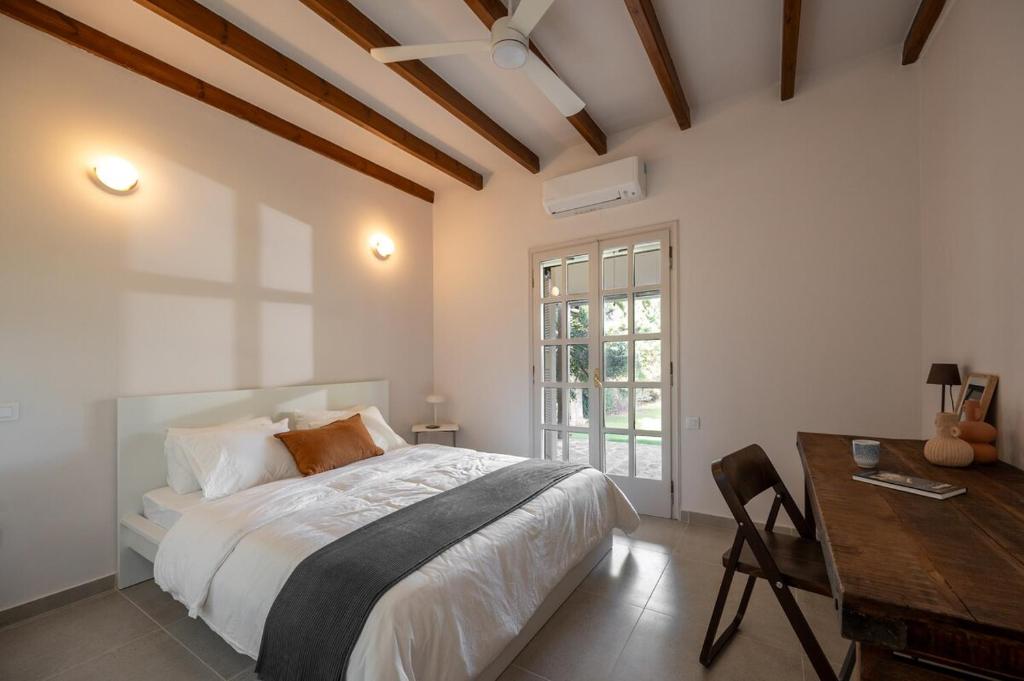 ein Schlafzimmer mit einem Bett, einem Tisch und einem Schreibtisch in der Unterkunft Anoixi vacation home with spectacular Evia landscapes in Loukísia