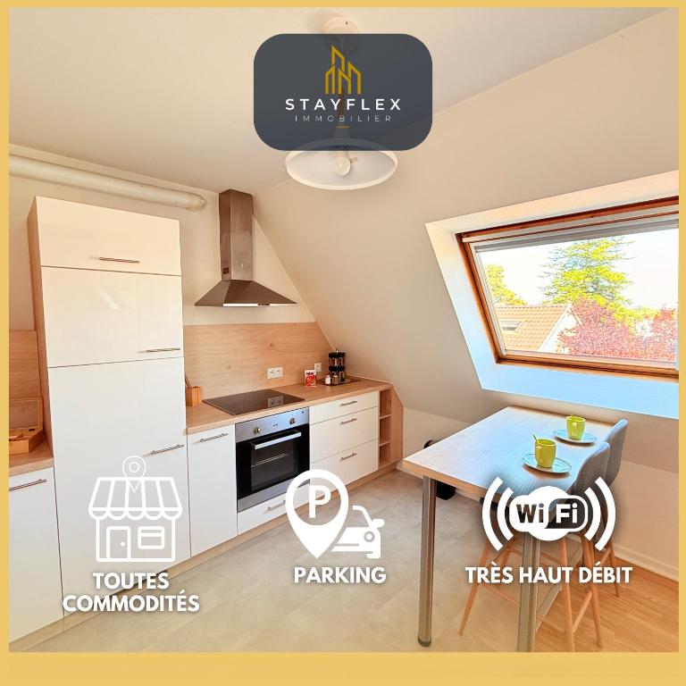 une petite cuisine avec une table et un réfrigérateur dans l'établissement Le Duplex des Tulipes - Parking included - Haguenau, à Haguenau