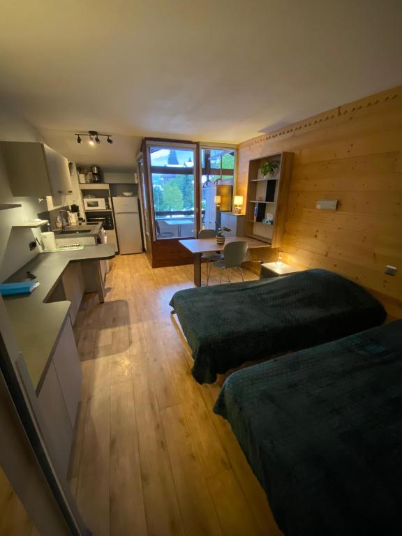 une grande chambre avec deux lits et une cuisine dans l'établissement Les Cybeles curistes, à Brides-les-Bains