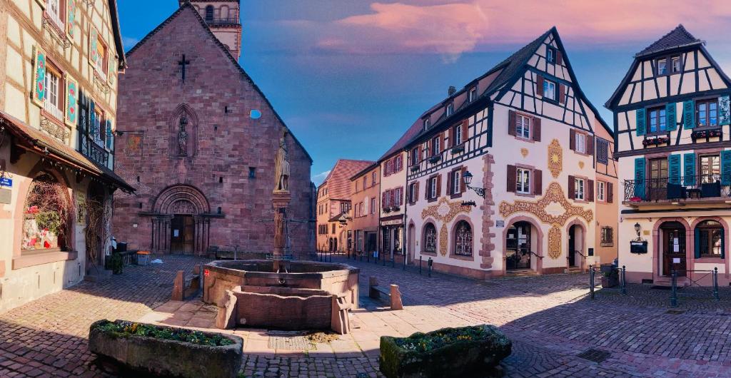 une rue de la ville avec de nombreux bâtiments et une église dans l'établissement Les Toits du Tonnelier - 64 m2 - situation plein centre médiéval - sauna - 2 garages, à Kaysersberg