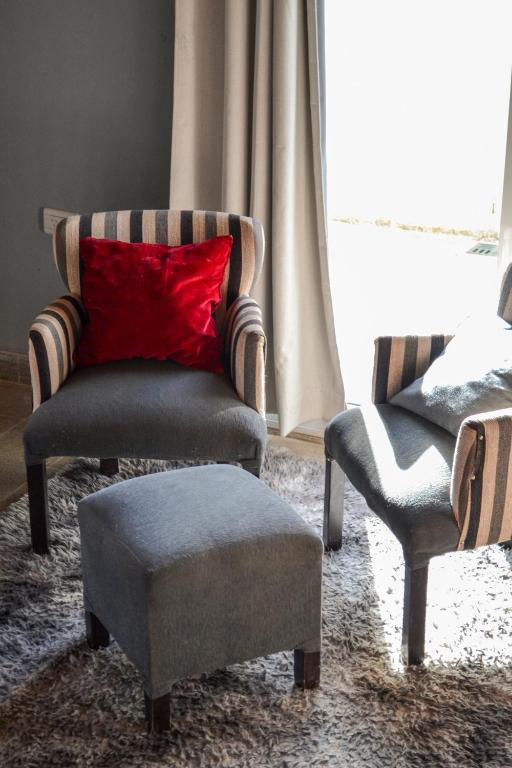 a living room with a chair and a red pillow at El Pedregal Cabaña rural 2 dorm Hasta 6 personas in Cafayate
