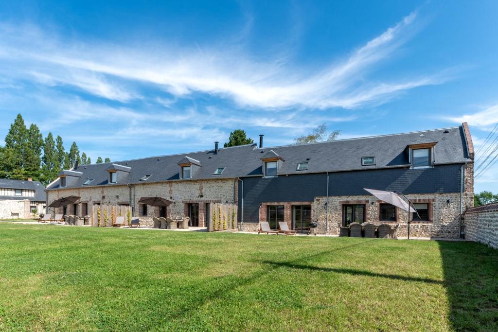 - une vue sur l'extérieur d'une grande maison avec une cour dans l'établissement Maisons H Normandie, à Cricquebœuf