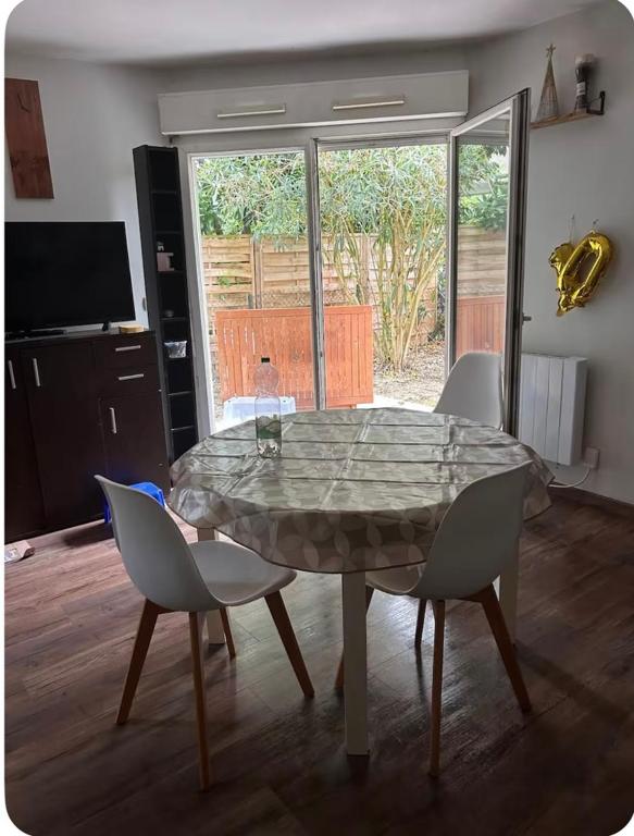 une table et des chaises dans un salon dans l'établissement T3 charmant petit nid douillet, à Eysines