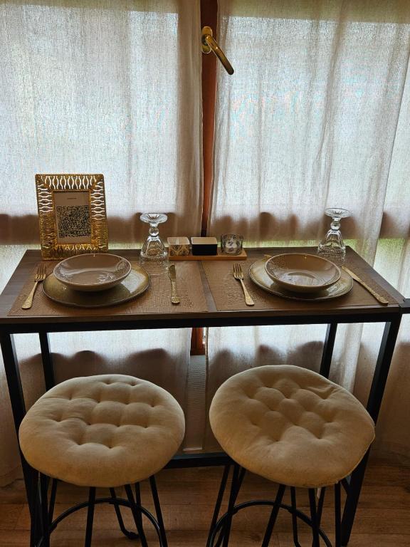 une table avec deux chaises et une table avec des assiettes et des verres dans l'établissement Studio gare, à Rouen