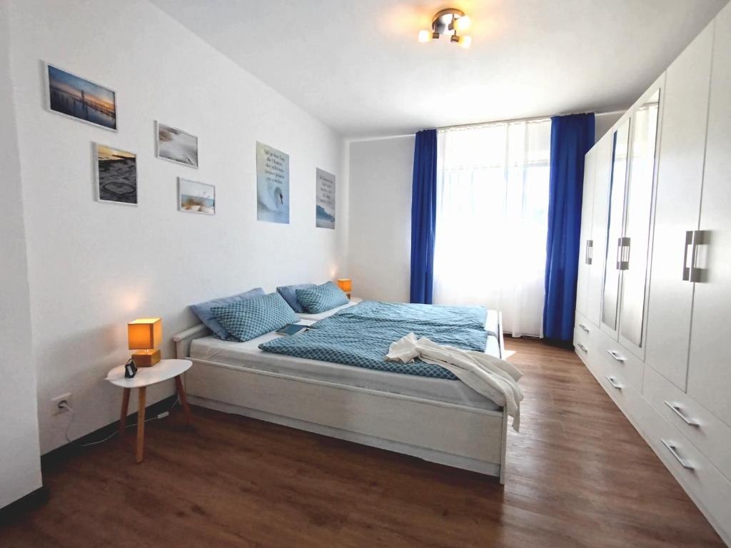 a bedroom with a bed with blue sheets and a window at Ferienwohnung am Ellerbach in Hessisch Oldendorf