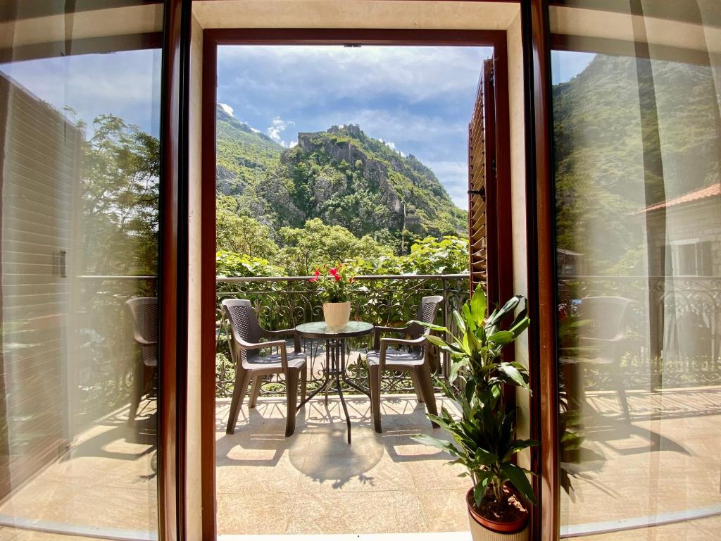 a balcony with a table and chairs and a mountain view at Fiumera Kotor Apartment in Kotor
