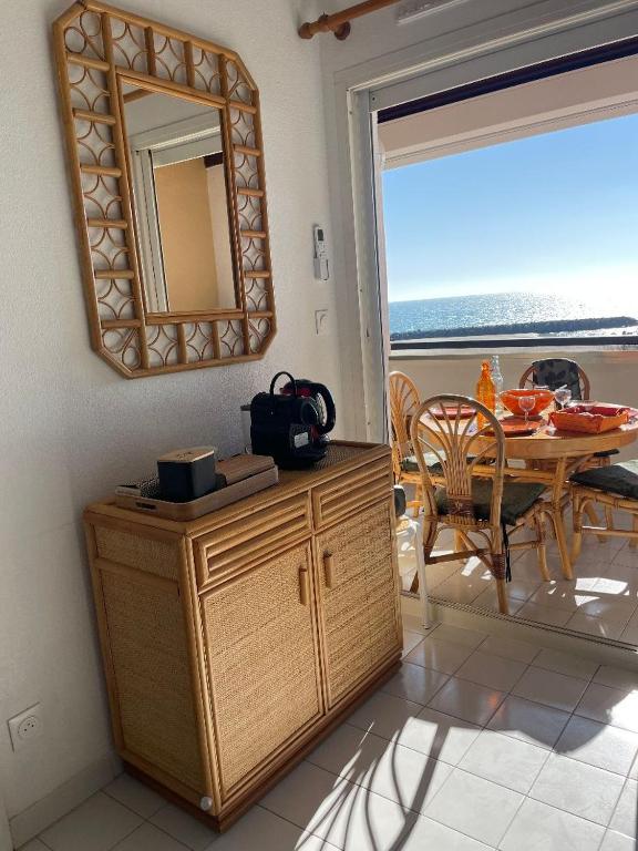 une salle à manger avec une table et un miroir dans l'établissement appartement face à la mer, piscine,parking,4couchages,clim, à La Celle-sous-Gouzon