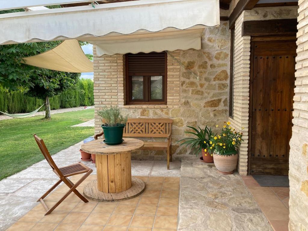 a patio with a table and a bench and an umbrella at La Huerta in Alcañiz