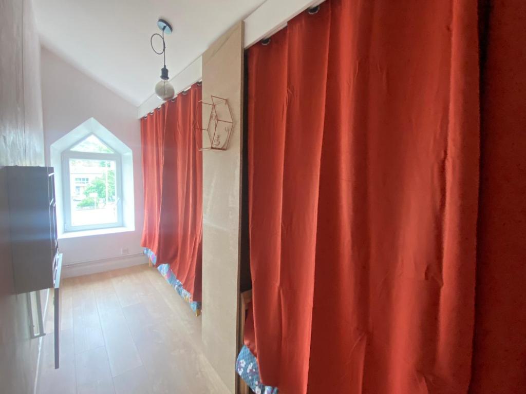 a room with red curtains and a window at Chez Catherine in Vorey
