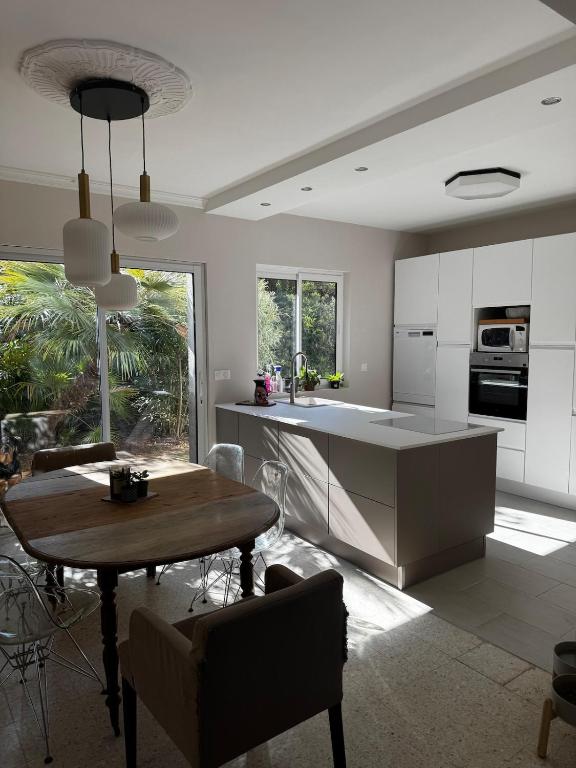 une cuisine et une salle à manger avec une table et des chaises dans l'établissement Entre mer et montagne, à Maureilhan-et-Raméjan