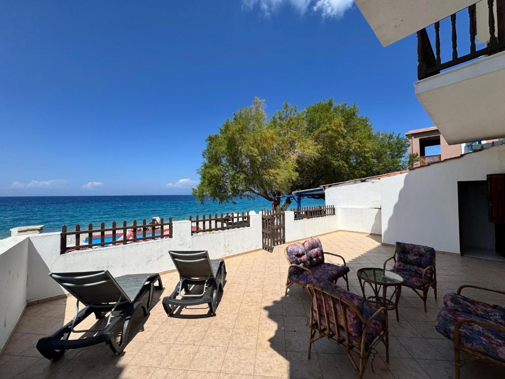 a group of chairs and tables on a patio overlooking the ocean at Sea View in Kámpos