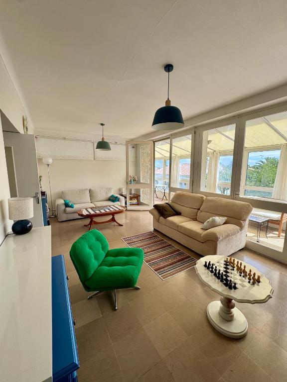 - un salon avec un canapé et un fauteuil vert dans l'établissement Spacieuse maison de 190 m2, jardin, la plage à 15min à pied - 6 personnes, à Les Sables-dʼOlonne